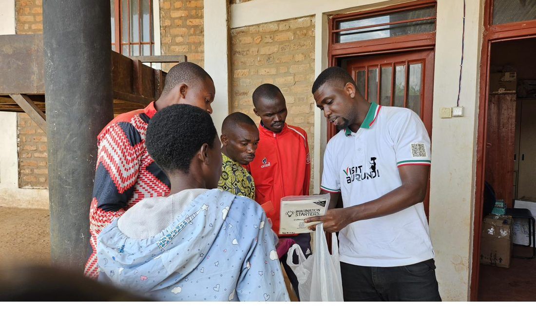 John handing over scholastic materials to teachers