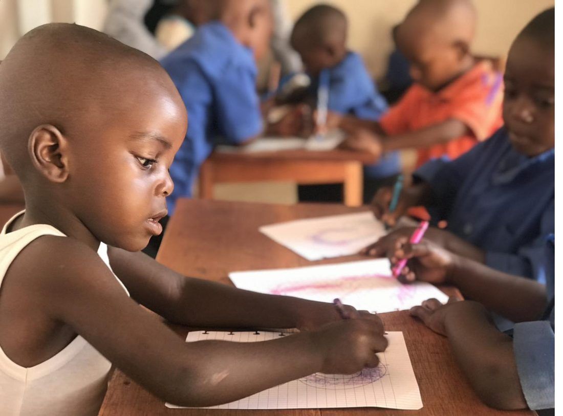 A child practicing writing in a preschool classroom