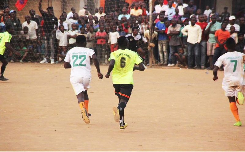 Football players in a match watched by their community